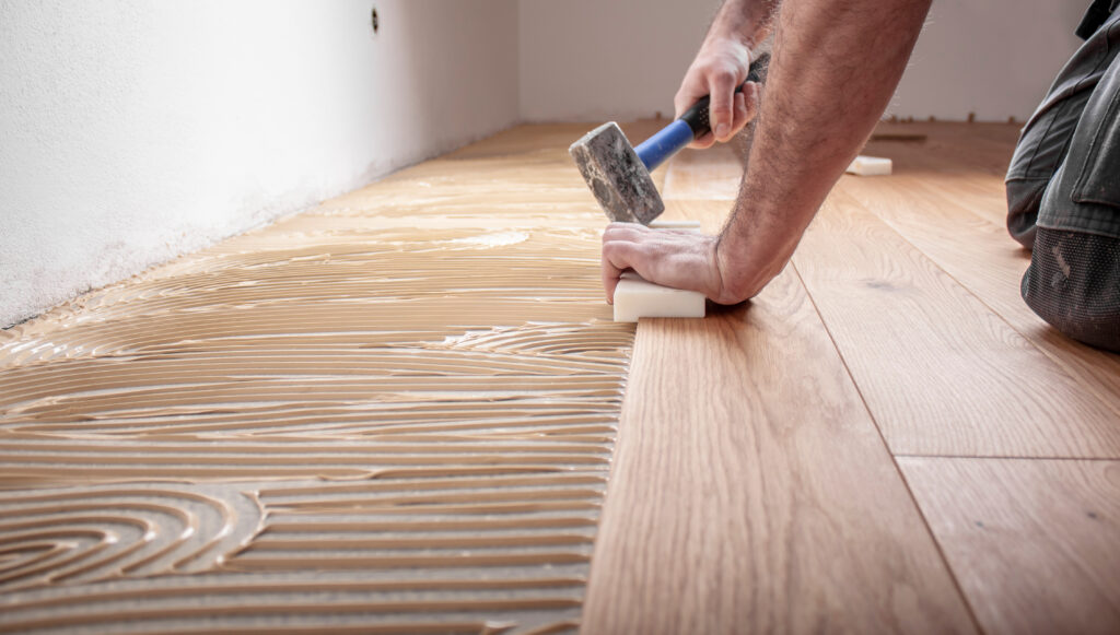 Craftsman,Lays,Parquet,Floor,And,Spreads,The,Glue,On,The